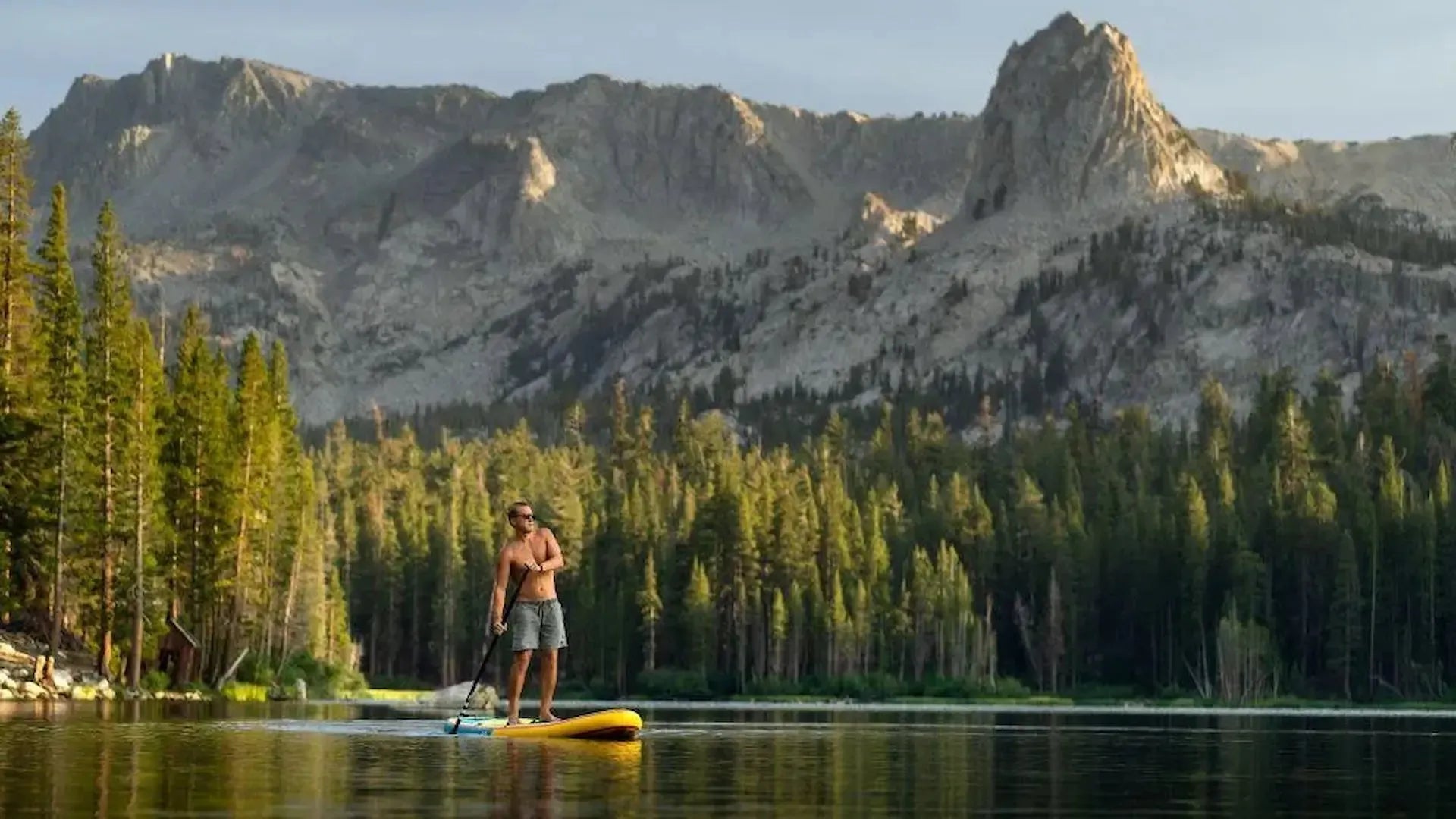 Person paddle boarding on calm water - mental and physical wellness benefits