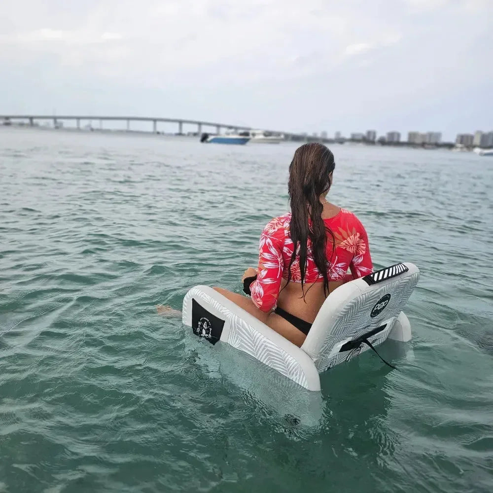 Inflatable POP Up Chair floating beside a dock, ideal for water and shoreline lounging.